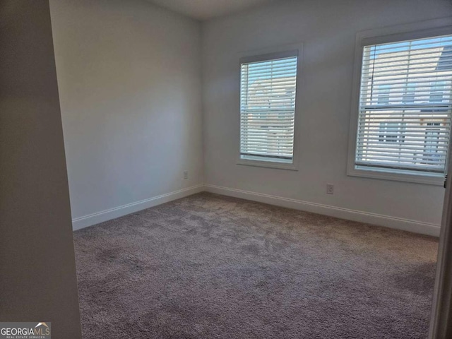 carpeted spare room with a healthy amount of sunlight and baseboards