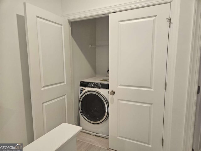 laundry room with laundry area, light wood-type flooring, and washer / dryer