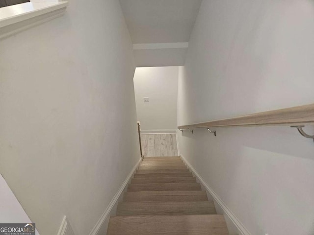 stairway featuring baseboards and wood finished floors