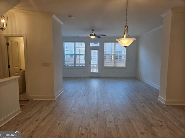 unfurnished living room featuring baseboards, wood finished floors, a ceiling fan, and crown molding