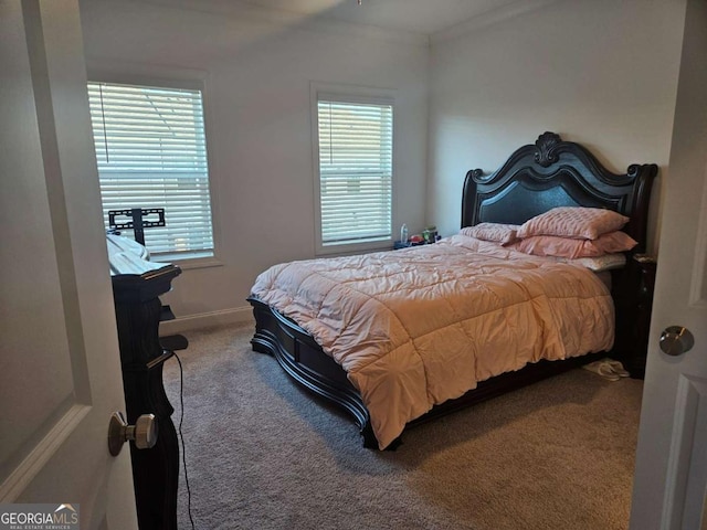 carpeted bedroom with multiple windows, baseboards, and ornamental molding