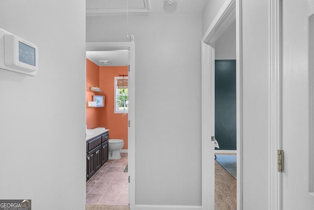 bathroom featuring toilet, vanity, and baseboards