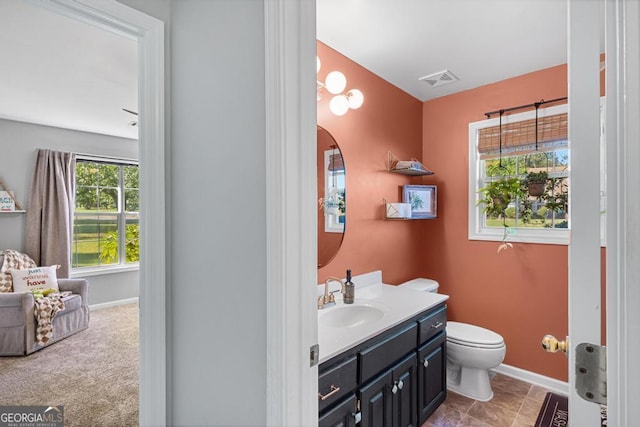 bathroom with visible vents, toilet, vanity, and baseboards