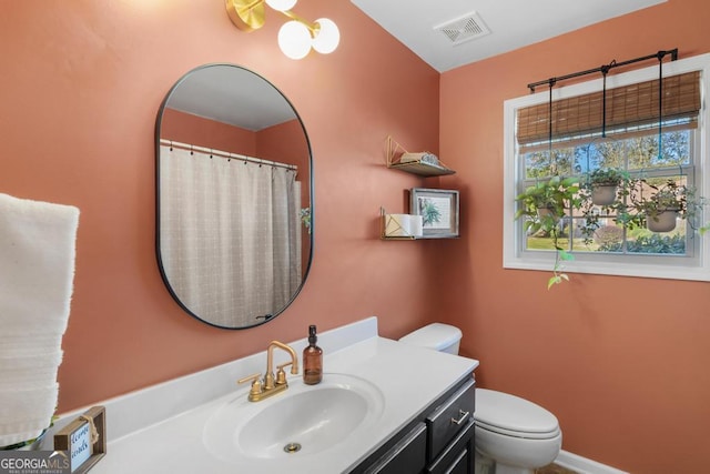 bathroom featuring visible vents, baseboards, toilet, a shower with shower curtain, and vanity