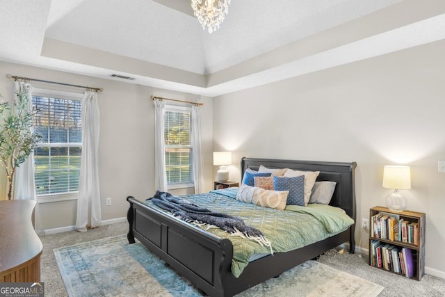 bedroom featuring visible vents, a notable chandelier, baseboards, carpet flooring, and a raised ceiling