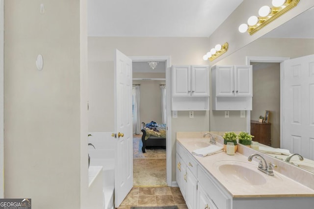 full bath with a sink, a bathtub, ensuite bath, and double vanity