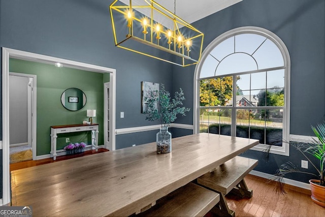 dining room with hardwood / wood-style flooring, baseboards, and a chandelier