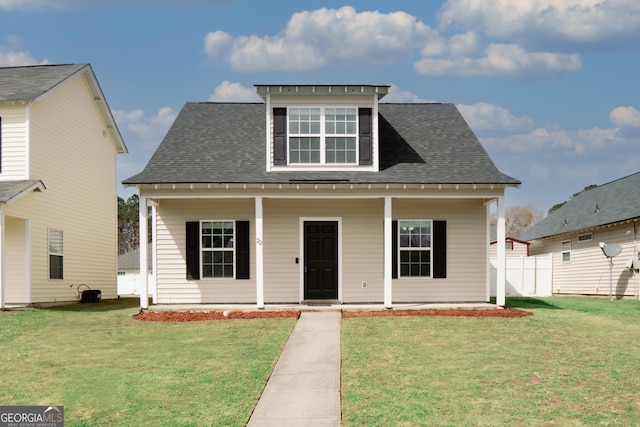 bungalow featuring covered porch, fence, a front lawn, and roof with shingles