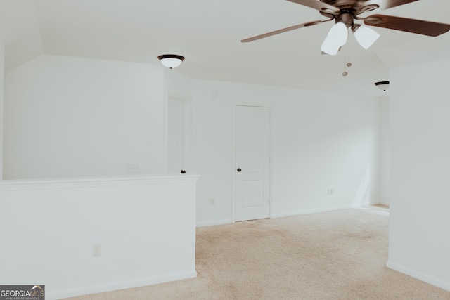 spare room featuring carpet flooring, baseboards, a ceiling fan, and vaulted ceiling