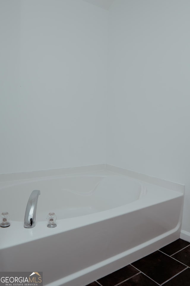 bathroom with tile patterned floors and a bath