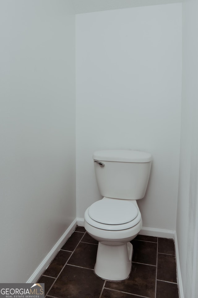 bathroom featuring tile patterned floors, baseboards, and toilet