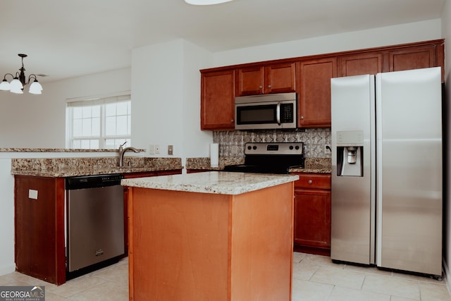 kitchen featuring tasteful backsplash, a center island, stainless steel appliances, an inviting chandelier, and light stone countertops