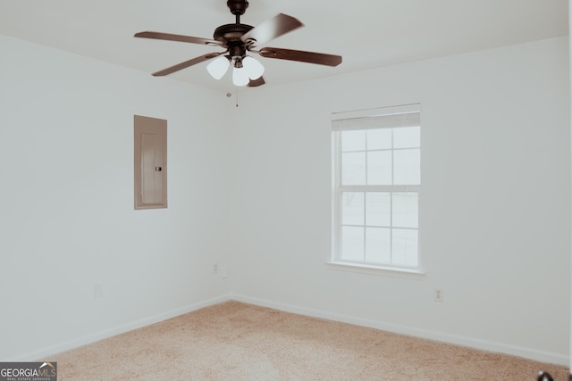 empty room featuring electric panel, a ceiling fan, baseboards, and carpet floors