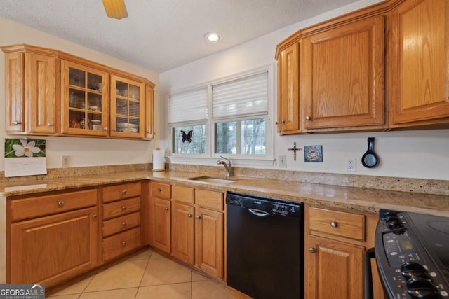 kitchen featuring black appliances, brown cabinets, a sink, and light tile patterned flooring