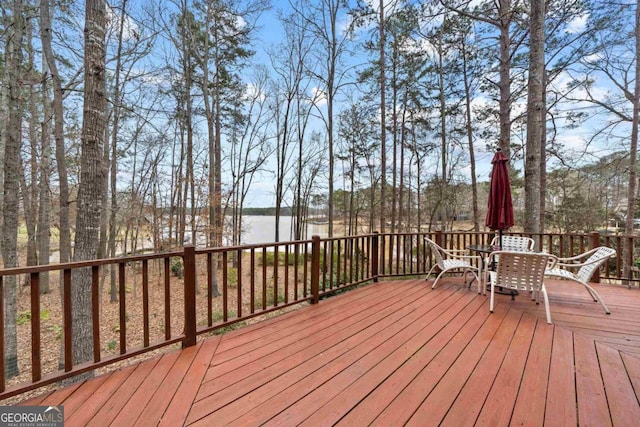 wooden deck featuring outdoor dining space and a water view