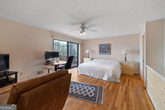 bedroom featuring light wood-type flooring, access to outside, ceiling fan, and a textured ceiling