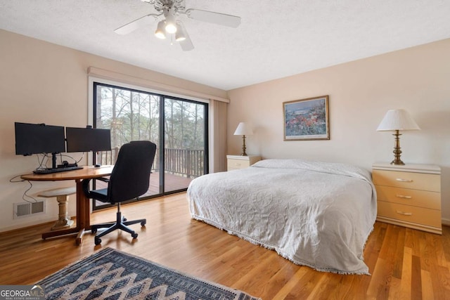 bedroom with visible vents, light wood-style flooring, a textured ceiling, access to outside, and baseboards