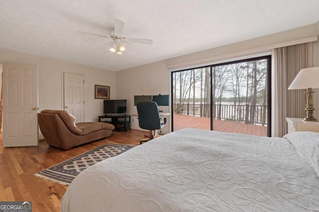 bedroom with access to outside, a textured ceiling, a ceiling fan, and wood finished floors