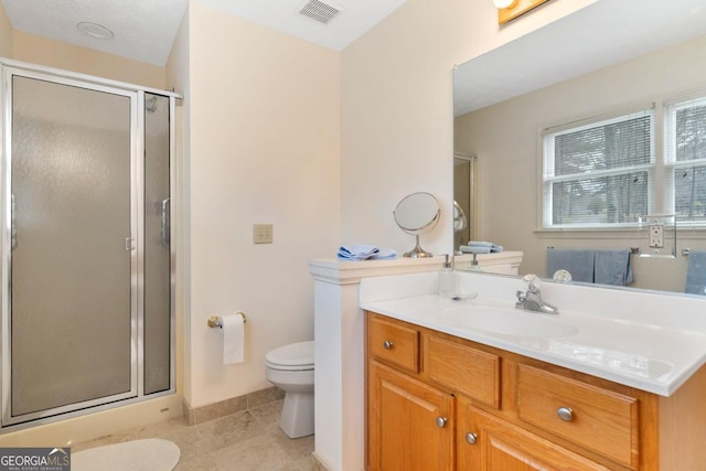 bathroom featuring tile patterned flooring, toilet, vanity, visible vents, and a stall shower