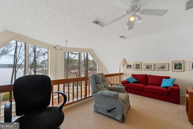 living area featuring vaulted ceiling, a textured ceiling, carpet, and visible vents