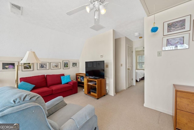 living area with visible vents, attic access, light carpet, vaulted ceiling, and a textured ceiling