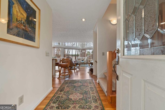 interior space featuring stairs, recessed lighting, baseboards, and wood finished floors