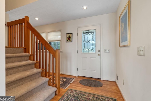 entryway featuring stairs, light wood-type flooring, baseboards, and recessed lighting