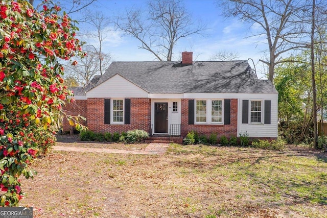 view of front of property featuring brick siding and a chimney