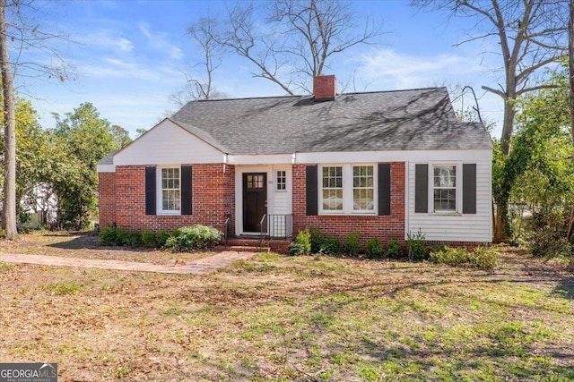 view of front of house with brick siding and a chimney