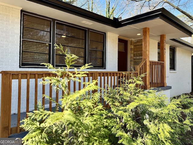 view of home's exterior with covered porch and brick siding