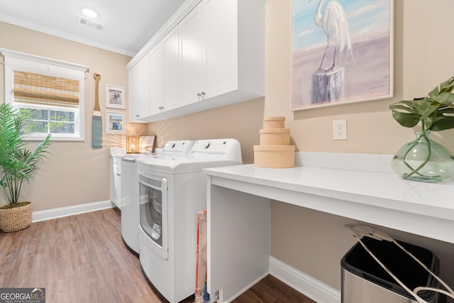 clothes washing area featuring cabinet space, visible vents, light wood-style floors, independent washer and dryer, and baseboards