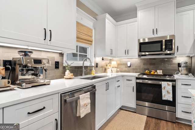 kitchen featuring stainless steel appliances, white cabinets, light countertops, ornamental molding, and decorative backsplash