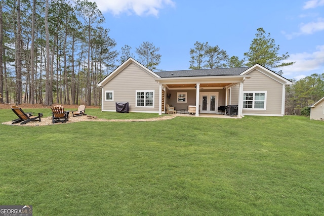 back of property with a patio, an outdoor fire pit, a ceiling fan, a yard, and french doors