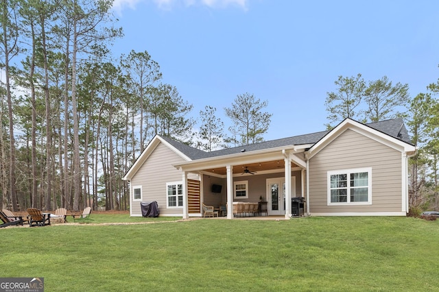 back of house featuring a yard, a patio area, ceiling fan, and a fire pit