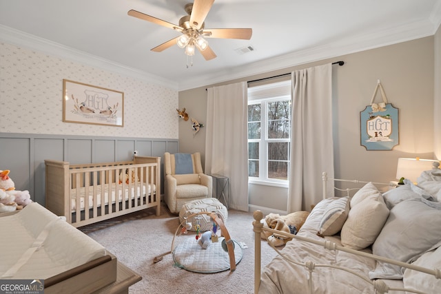 carpeted bedroom featuring ornamental molding, wainscoting, visible vents, and wallpapered walls