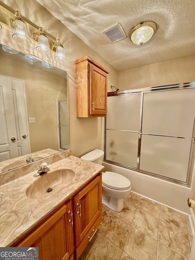 bathroom featuring visible vents, toilet, combined bath / shower with glass door, a textured ceiling, and tile patterned floors