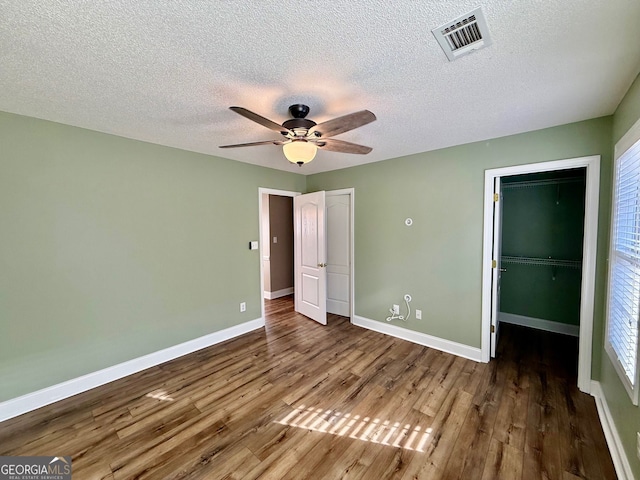 unfurnished bedroom with visible vents, baseboards, and wood finished floors