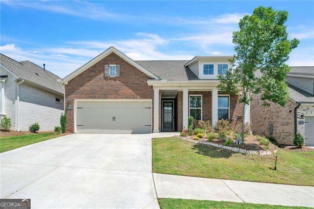 view of front of home with a garage, driveway, brick siding, and a front yard