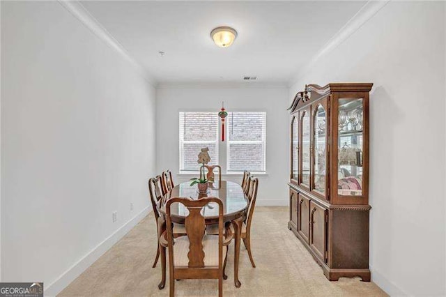 dining space featuring visible vents, ornamental molding, light colored carpet, and baseboards