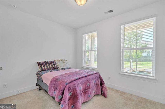 carpeted bedroom with visible vents and baseboards