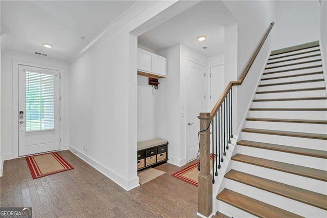 foyer entrance with recessed lighting, wood finished floors, visible vents, baseboards, and stairs