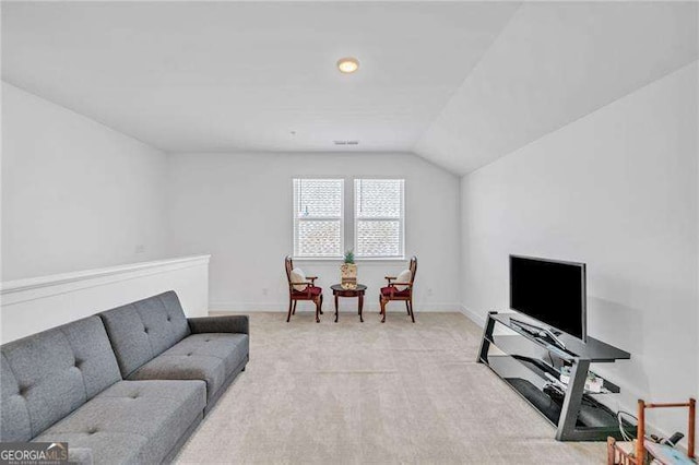 living room with lofted ceiling, visible vents, baseboards, and light colored carpet