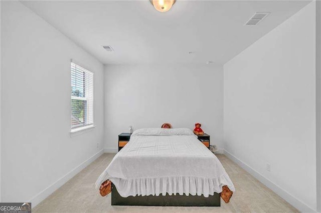 bedroom with light colored carpet, visible vents, and baseboards