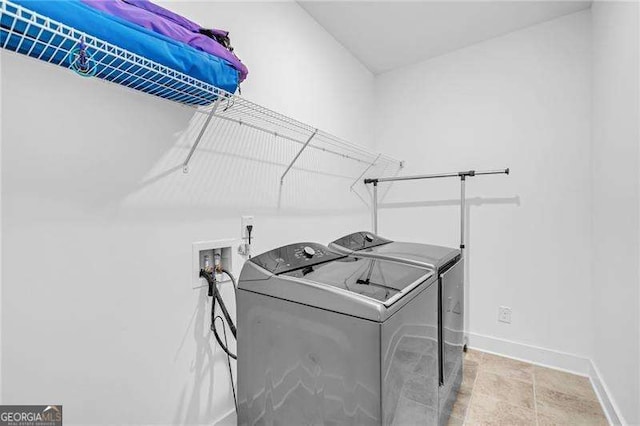 clothes washing area with laundry area, baseboards, and independent washer and dryer