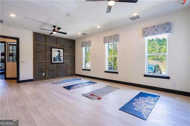 workout area featuring a ceiling fan, baseboards, visible vents, and wood finished floors