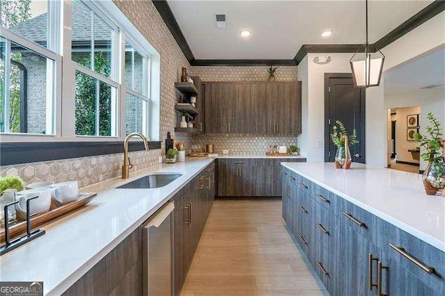 kitchen featuring dishwasher, open shelves, a sink, and light countertops