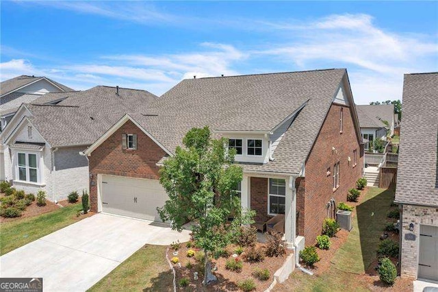 view of front of property featuring brick siding, a shingled roof, an AC wall unit, a garage, and driveway