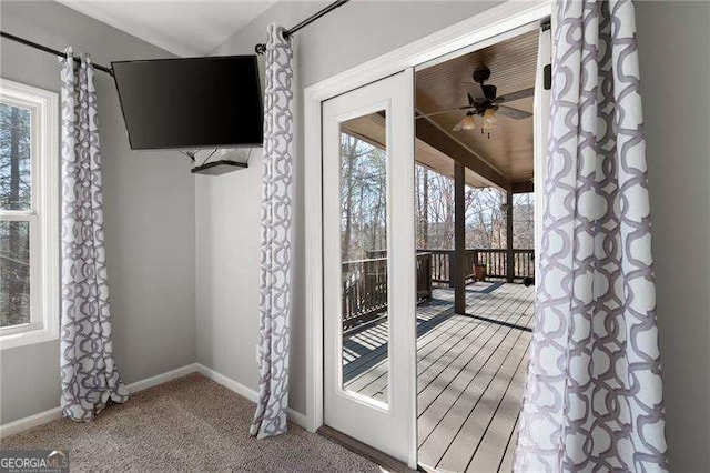 entryway with light carpet, ceiling fan, baseboards, and lofted ceiling