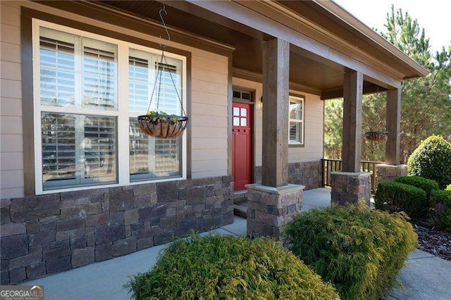 property entrance with covered porch and stone siding