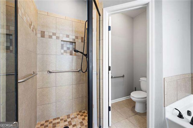 bathroom with baseboards, toilet, tile patterned floors, a garden tub, and a shower stall